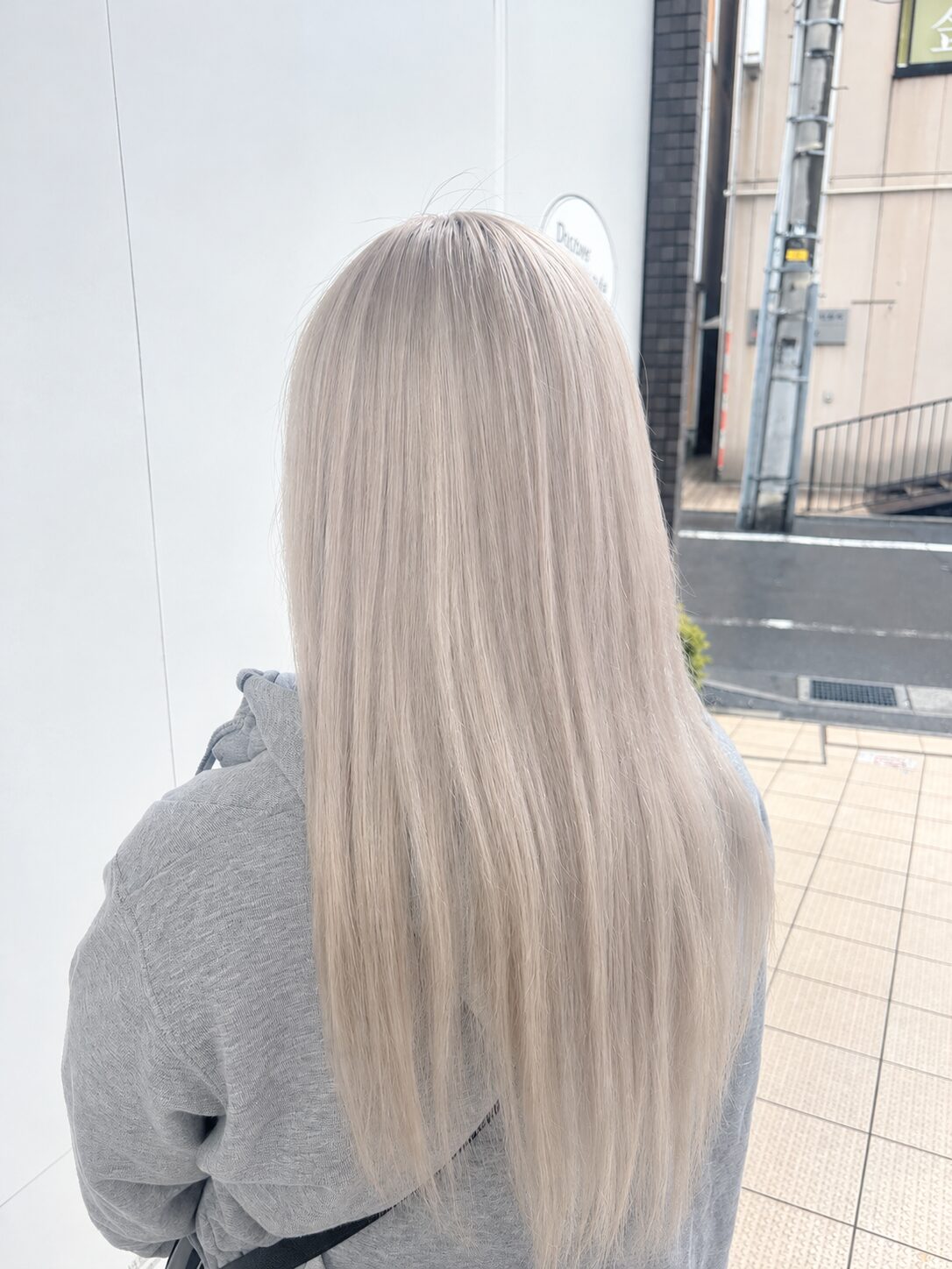 背中側から見たロングの淡いベージュ系ダブルカラー(Hair & Make anyhow)