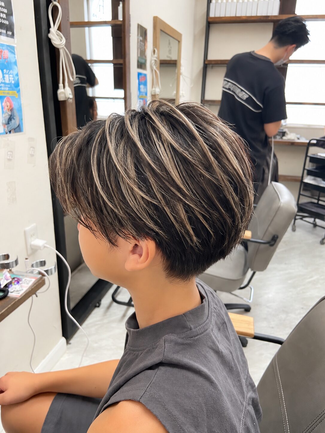黒髪ベースにベージュ系ハイライトを入れたショートの横姿（Hair & Make anyhow）